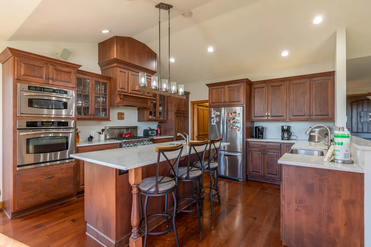 The kitchen is the focal point here, featuring a spacious island, warm wooden cabinetry, and stainless steel Viking appliances. The setup is designed for cooking, entertaining, and hosting family gatherings, with plenty of room for culinary adventures.
