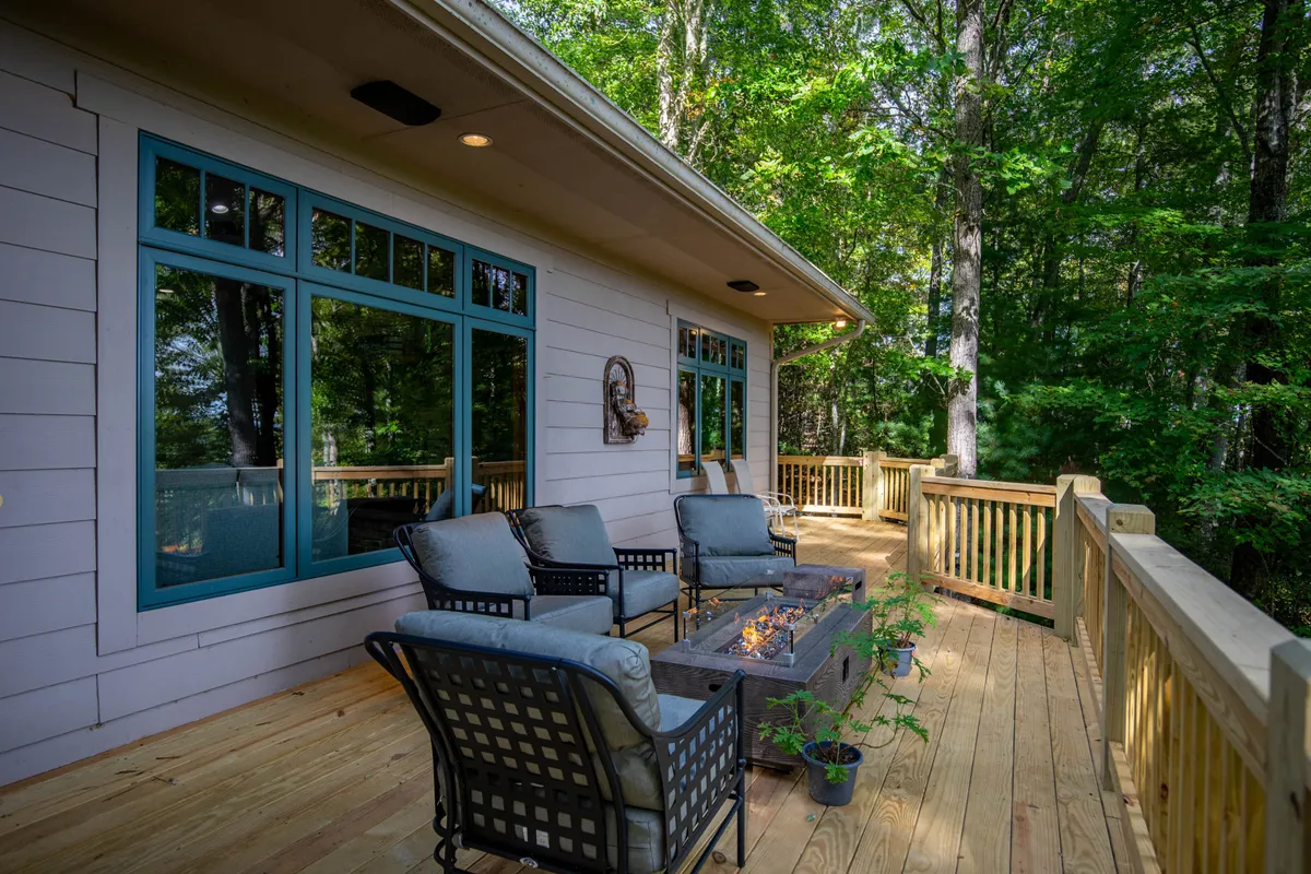 A cozy exterior scene featuring a comfortable seating area and a gas fire pit set amongst greenery. The inviting setup is perfect for evening gatherings, storytelling, or stargazing with loved ones.