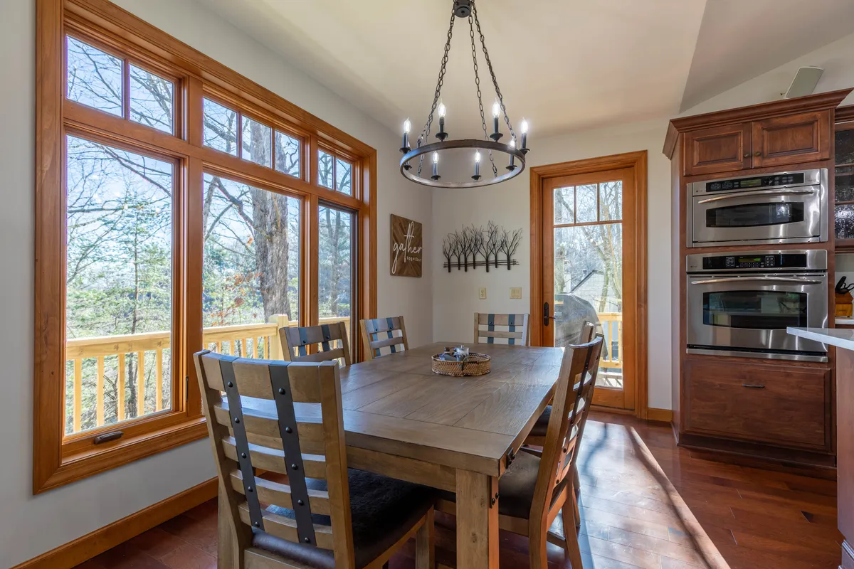 An inviting dining area with a spacious table, elegant chandelier, and large windows that frame the outdoor scenery. The space encourages family meals, celebrations, and quiet moments—mirroring the year-round possibilities at Tobey’s Den.